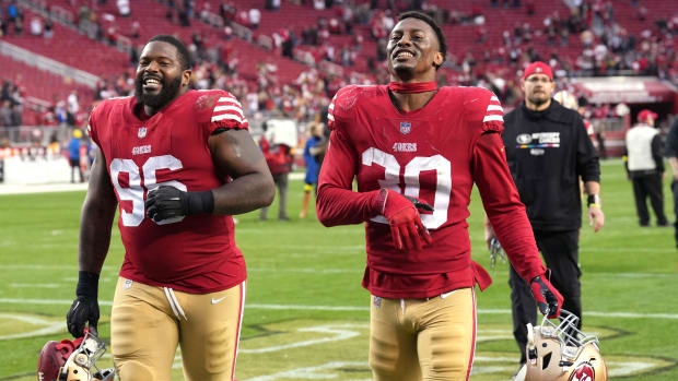 Jan 8, 2023; Santa Clara, California, USA; San Francisco 49ers defensive tackle T.Y. McGill (96) and safety George Odum (30) jog off the field after defeating the Arizona Cardinals at Levi's Stadium. Mandatory Credit: Darren Yamashita-USA TODAY Sports